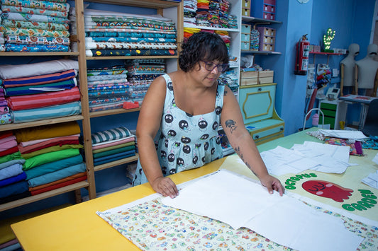 Adriana cortando un patrón sobre tela estampada en el taller de Octopus Garden en Zaragoza